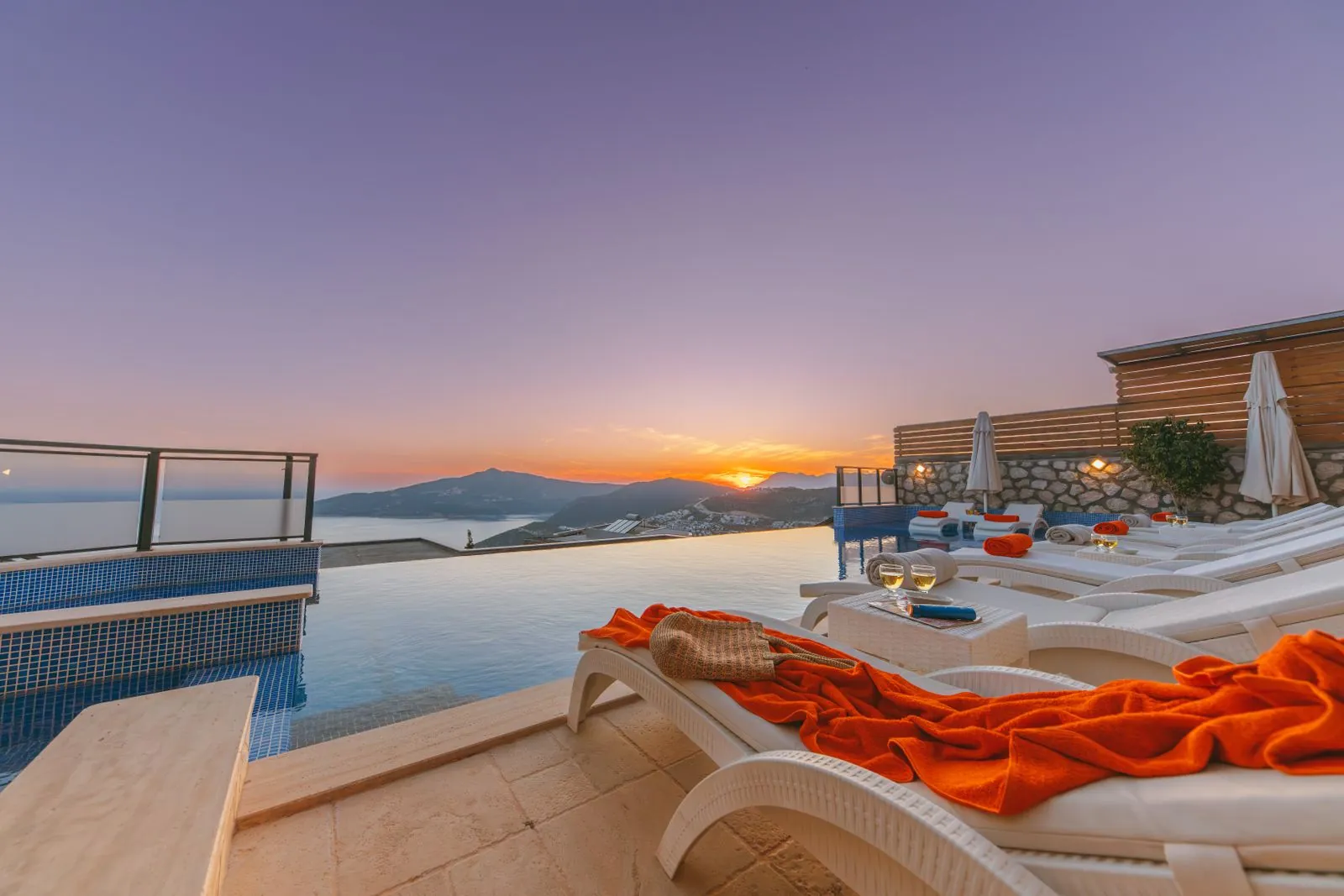 Sunbeds beside an infinity pool at sunset. Photo by Ahmet ÇÖTÜR.