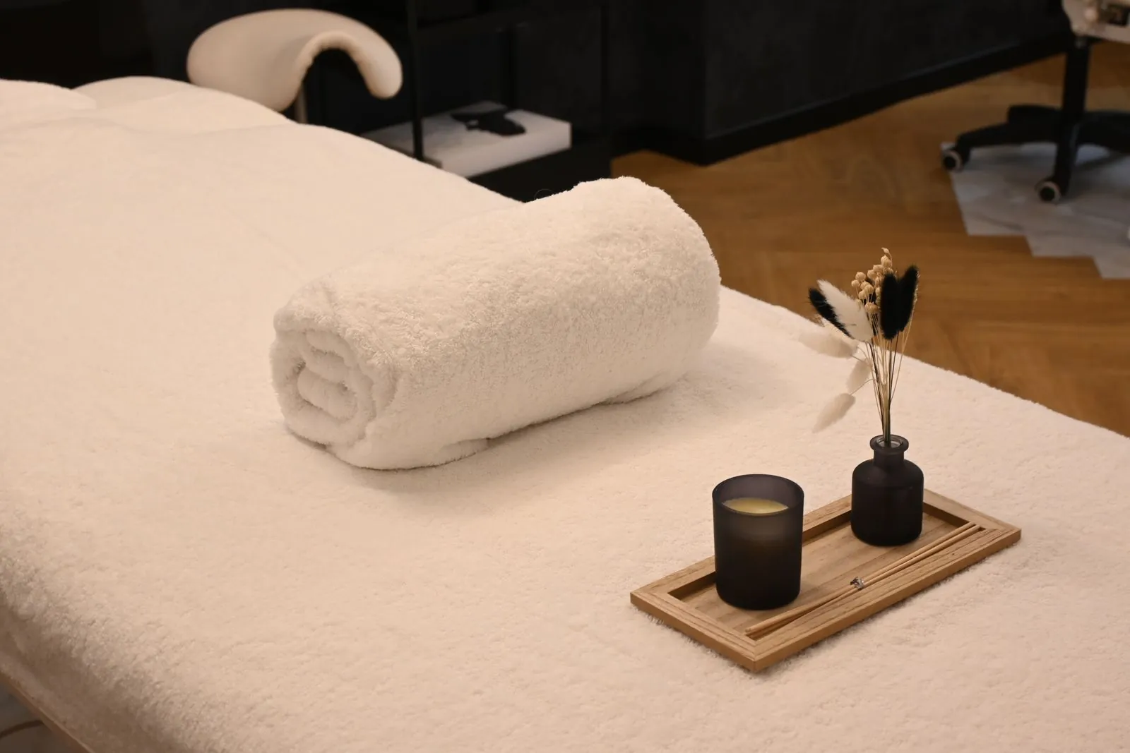 Spa massage table with a rolled towel and candle. Photo by Marine Fougère.